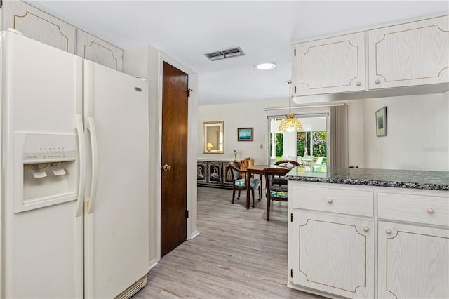 kitchen featuring white refrigerator with ice dispenser, light wood finished floors, dark stone counters, white cabinets, and recessed lighting