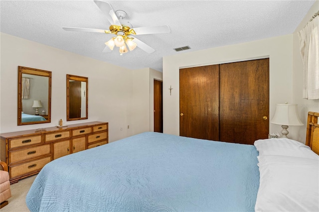 bedroom with a closet, a textured ceiling, and a ceiling fan