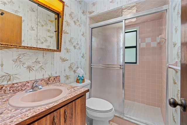 full bath with wallpapered walls, vanity, and a stall shower