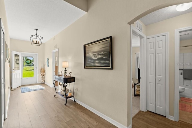 318 Two Oaks Dr, Edgewater, FL 32141 - entrance foyer featuring arched walkways, light wood-style floors, and a chandelier