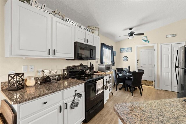 318 Two Oaks Dr, Edgewater, FL 32141 - kitchen with black appliances, a ceiling fan, light wood-type flooring, white cabinetry, and dark stone countertops