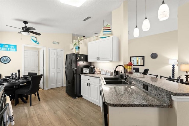 318 Two Oaks Dr, Edgewater, FL 32141 - kitchen featuring freestanding refrigerator, light wood finished floors, a peninsula, ceiling fan, and white cabinets