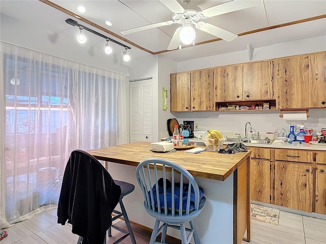 44 Fore Dr, New Smyrna Beach, FL 32168 - kitchen with wood counters, a breakfast bar, brown cabinetry, and ceiling fan