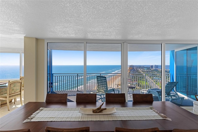 2625 S Atlantic Ave Unit 28Se, Daytona Beach Shores, FL 32118 - dining space with a textured ceiling, a wall of windows, and a water view