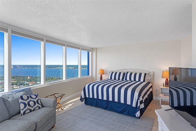2625 S Atlantic Ave Unit 28Se, Daytona Beach Shores, FL 32118 - bedroom featuring carpet, a water view, and a textured ceiling