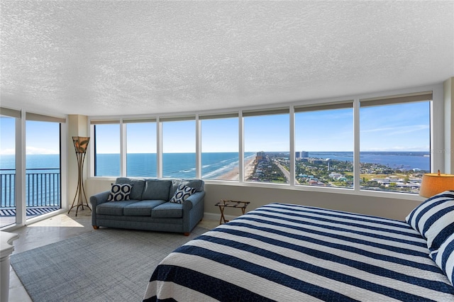 2625 S Atlantic Ave Unit 28Se, Daytona Beach Shores, FL 32118 - bedroom featuring access to outside, a water view, and a textured ceiling
