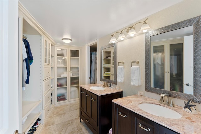2625 S Atlantic Ave Unit 28Se, Daytona Beach Shores, FL 32118 - bathroom with two vanities, a spacious closet, and a textured wall