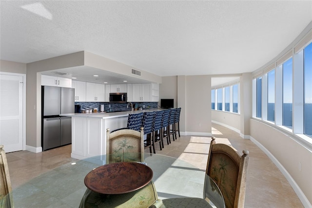 2625 S Atlantic Ave Unit 28Se, Daytona Beach Shores, FL 32118 - dining room featuring baseboards and a textured ceiling