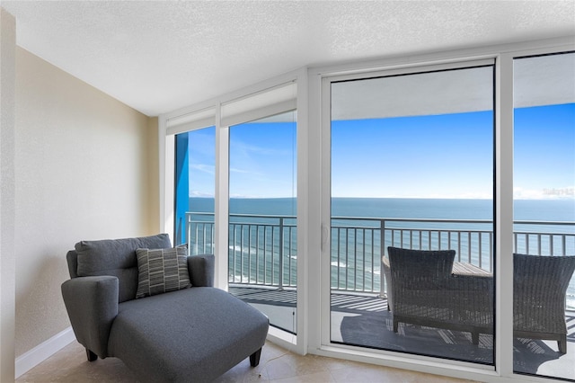 2625 S Atlantic Ave Unit 28Se, Daytona Beach Shores, FL 32118 - sitting room with expansive windows, a water view, a textured ceiling, and tile patterned floors