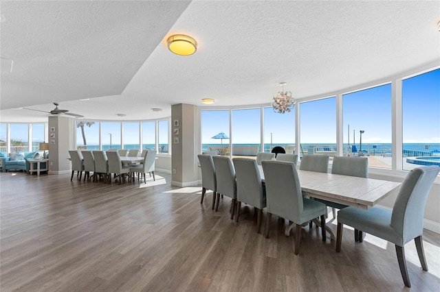 2625 S Atlantic Ave Unit 28Se, Daytona Beach Shores, FL 32118 - dining area with wood finished floors, a textured ceiling, a water view, a chandelier, and floor to ceiling windows