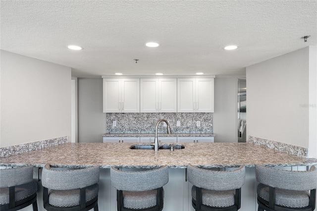 2625 S Atlantic Ave Unit 28Se, Daytona Beach Shores, FL 32118 - kitchen featuring tasteful backsplash, a peninsula, white cabinetry, a breakfast bar area, and recessed lighting