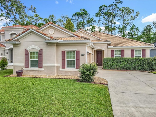 3361 Pegaso Ave, New Smyrna Beach, FL 32168 - mediterranean / spanish house with stucco siding, a front lawn, and concrete driveway