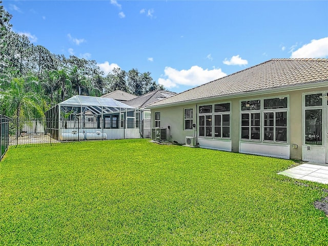 3361 Pegaso Ave, New Smyrna Beach, FL 32168 - back of house with stucco siding, a fenced backyard, a lanai, and a tile roof