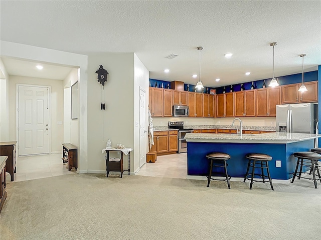 3361 Pegaso Ave, New Smyrna Beach, FL 32168 - kitchen with appliances with stainless steel finishes, light carpet, a kitchen breakfast bar, brown cabinetry, and hanging light fixtures