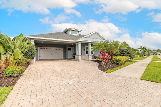 2931 Bella Flore Ter, New Smyrna Beach, FL 32168 - view of front of property featuring decorative driveway, covered porch, an attached garage, stucco siding, and a shingled roof