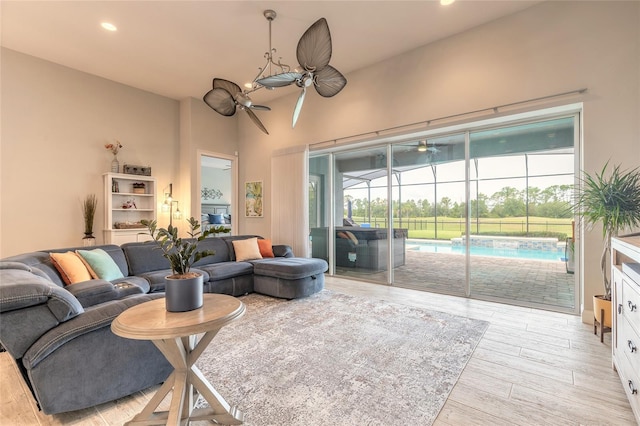 2931 Bella Flore Ter, New Smyrna Beach, FL 32168 - living area with a ceiling fan, light wood-style flooring, recessed lighting, a sunroom, and a towering ceiling