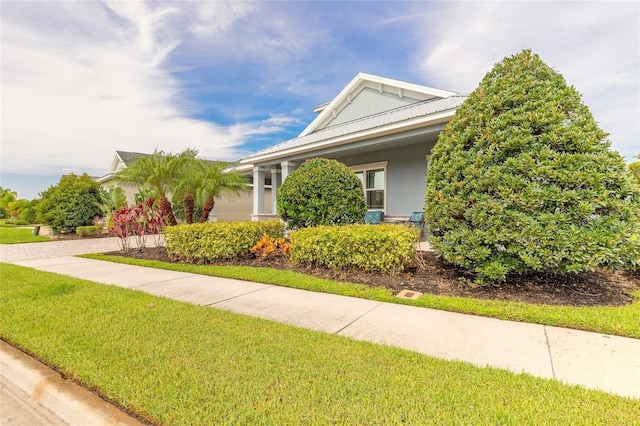 2931 Bella Flore Ter, New Smyrna Beach, FL 32168 - view of front facade with stucco siding, a front yard, and a metal roof
