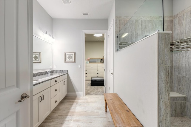2931 Bella Flore Ter, New Smyrna Beach, FL 32168 - ensuite bathroom with double vanity, a walk in shower, and wood finished floors