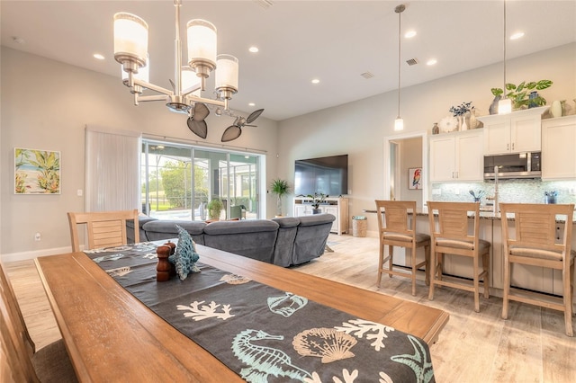 2931 Bella Flore Ter, New Smyrna Beach, FL 32168 - dining room with a towering ceiling, a chandelier, light wood-style floors, and recessed lighting