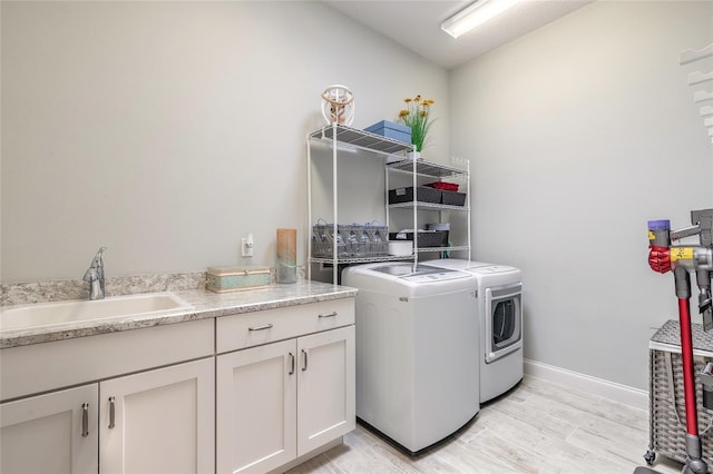 2931 Bella Flore Ter, New Smyrna Beach, FL 32168 - laundry room with separate washer and dryer, cabinet space, and light wood finished floors