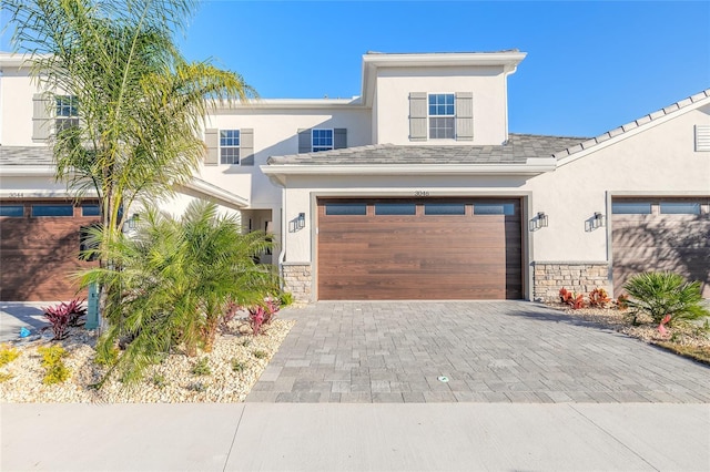 3044 Isles Way, New Smyrna Beach, FL 32168 - view of front of property with stone siding, decorative driveway, stucco siding, and a garage