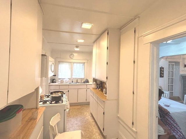 322 Taylor Ave, Daytona Beach, FL 32114 - kitchen featuring white cabinetry, light countertops, and white appliances