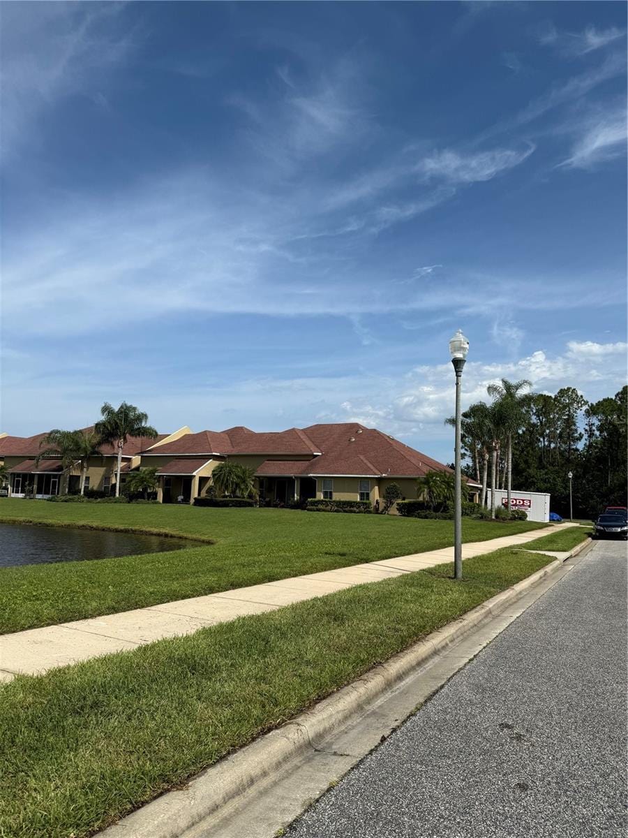 3604 Romea Cir, New Smyrna Beach, FL 32168 - view of front of house featuring a front yard and a water view
