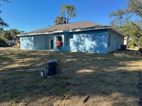 rear view of property with a yard