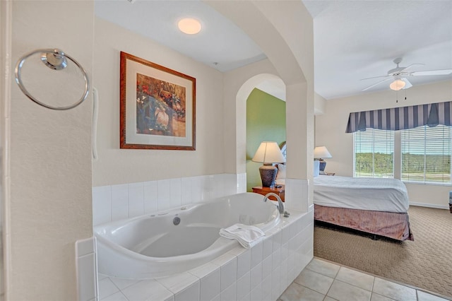 bathroom featuring a relaxing tiled tub, ceiling fan, and tile patterned floors