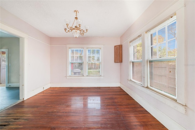 tiled empty room featuring an inviting chandelier