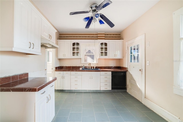 kitchen featuring ceiling fan, light tile floors, sink, black dishwasher, and white cabinetry