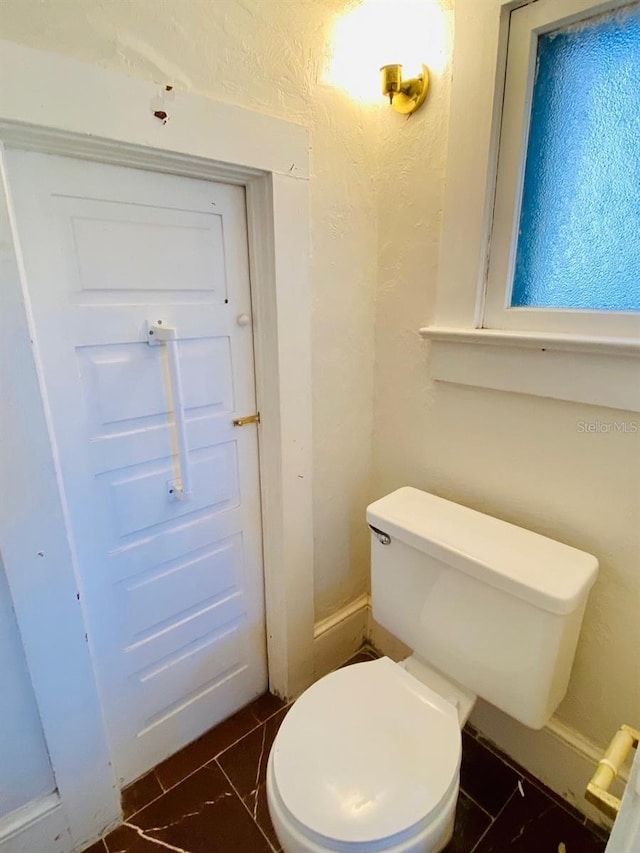 bathroom featuring tile flooring and toilet