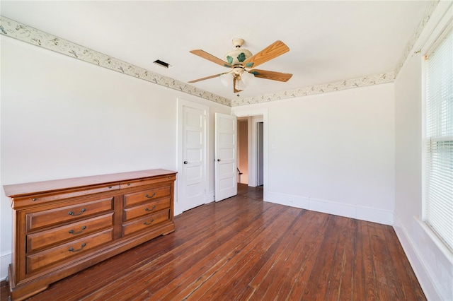 spare room with dark wood-type flooring, ceiling fan, and a wealth of natural light