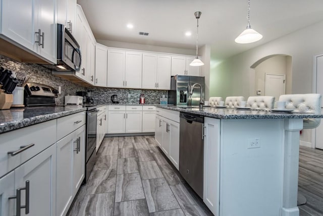 kitchen featuring white cabinets, tasteful backsplash, and appliances with stainless steel finishes