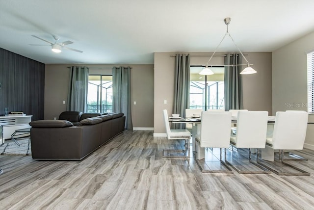 dining area with light wood-type flooring and ceiling fan with notable chandelier