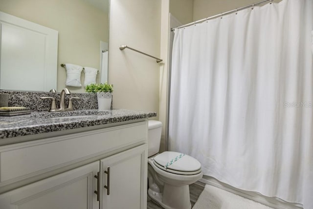 bathroom with toilet, vanity, and hardwood / wood-style flooring