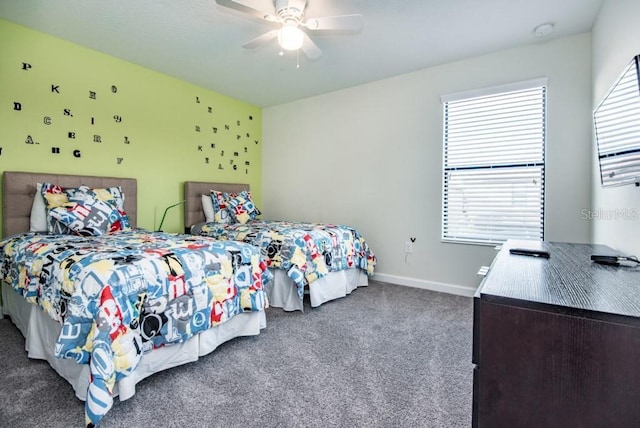 bedroom featuring ceiling fan, multiple windows, and dark colored carpet