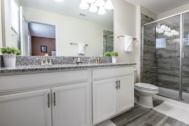 bathroom featuring walk in shower, toilet, double sink vanity, hardwood / wood-style floors, and an inviting chandelier