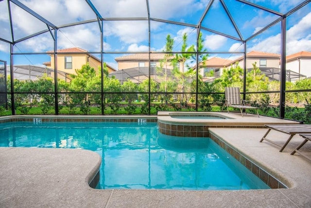 view of swimming pool with a patio area, an in ground hot tub, and a lanai