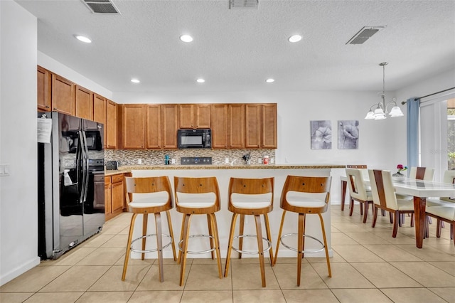 kitchen with tasteful backsplash, hanging light fixtures, a chandelier, black appliances, and a center island