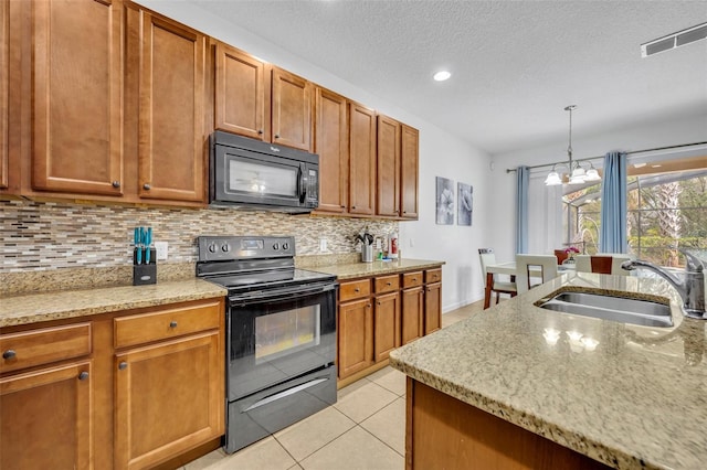 kitchen with black appliances, decorative light fixtures, sink, a chandelier, and light tile patterned floors