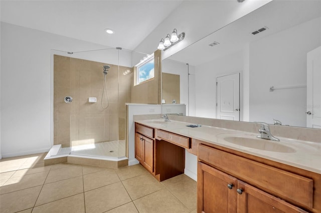 bathroom featuring vanity, tile patterned flooring, and tiled shower