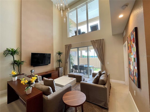 tiled living room featuring a chandelier and a high ceiling