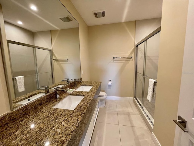 bathroom featuring walk in shower, toilet, dual sinks, tile flooring, and large vanity