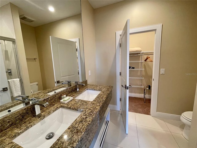 bathroom featuring double sink vanity, tile floors, and toilet