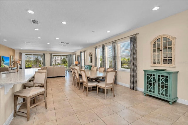 dining space with light tile floors, sink, and a wealth of natural light