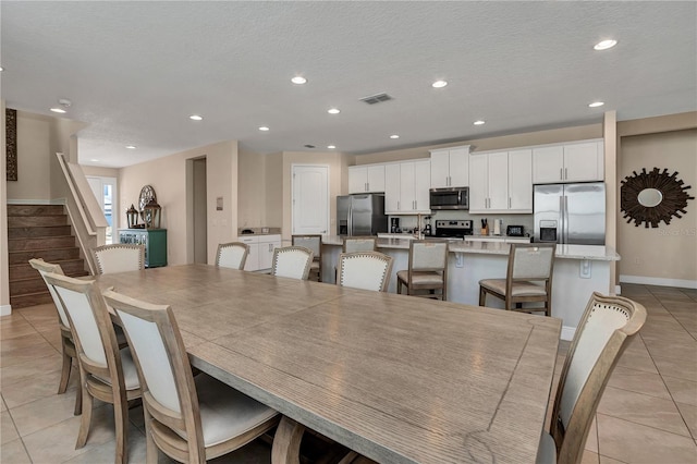 tiled dining space with a textured ceiling