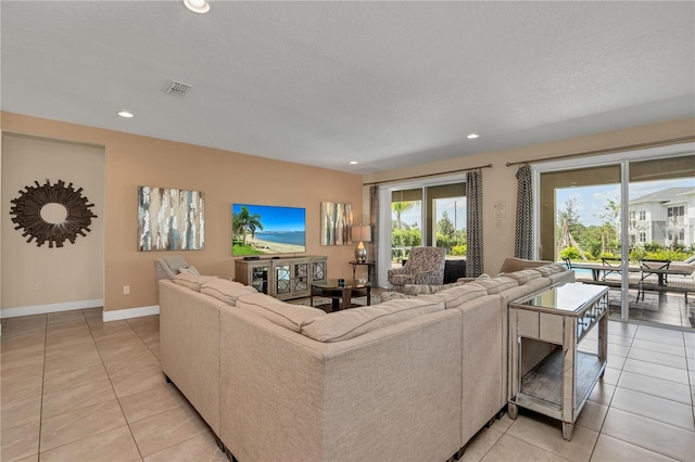 living room featuring a textured ceiling and light tile floors