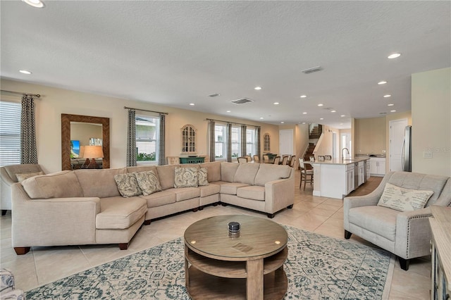 tiled living room with a textured ceiling and sink