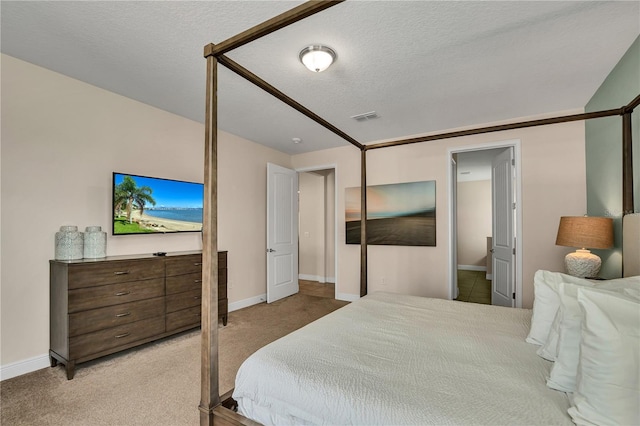 bedroom with a textured ceiling and light carpet